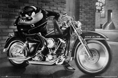 a black and white photo of a mickey mouse on a motorcycle