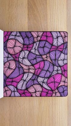 a purple and pink mouse pad sitting on top of a wooden table