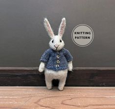 a knitted white rabbit wearing a blue sweater