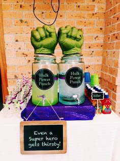 there are two jars with green hands on top of each other and a sign that says, even a super hero gets thirsty