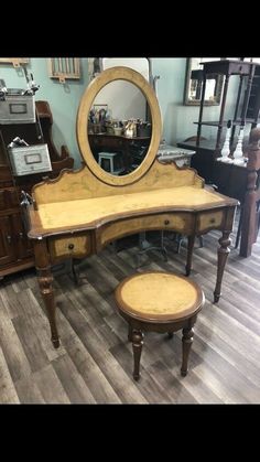 an antique vanity with stool and mirror