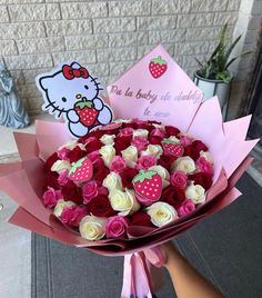 a bouquet of roses with hello kitty on the side and a card for someone's birthday