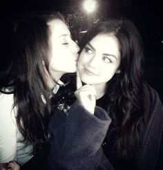 two women are kissing each other in front of a camera light at the same time