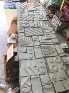 several pieces of white tile sitting on top of a table next to boxes and other items