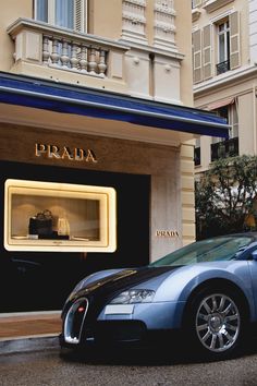 a bugatti car parked in front of a store