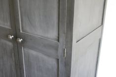 an old wooden armoire with two doors and knobs on the bottom half of it