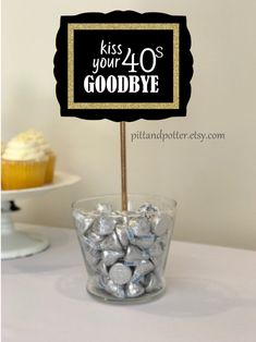 a cupcake on a stick with a sign that says kiss your 30's goodbye