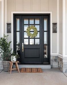 a black front door with a wreath on it