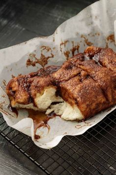 a pastry sitting on top of a cooling rack covered in chocolate sauce and powdered sugar