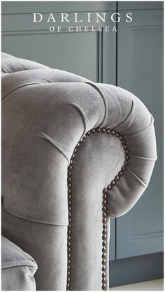 the back end of a grey couch with chains on it's arms and legs