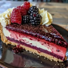 a piece of cheesecake with berries and whipped cream is on a black plate, ready to be eaten