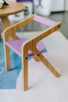 a purple chair sitting next to a wooden table