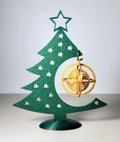 an ornament shaped like a christmas tree with a compass on top and stars around it