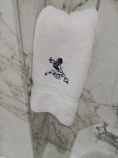 a white towel hanging on the side of a bathroom wall