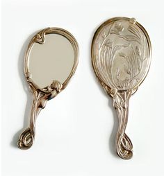 two antique mirrors are sitting side by side on a white surface the mirror has an image of a woman's face in it