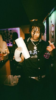 a man with dreadlocks holding a roll of paper