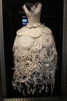 a white dress made out of paper with musical notes on the bottom and back side