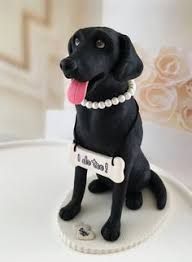 a black dog figurine sitting on top of a cake