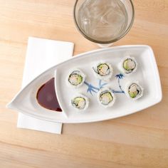 sushi on a white plate next to a glass of water