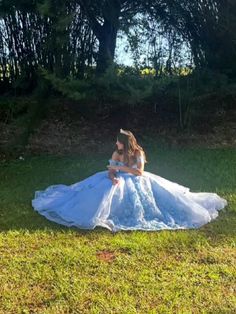 a woman in a wedding dress sitting on the grass