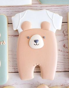 decorated cookies in the shape of teddy bears and other items on a white wooden surface