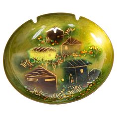 a green bowl with small houses painted on it