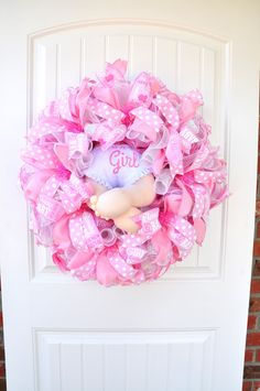 a pink wreath that says girl on it with a teddy bear in the center and polka dots