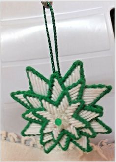 a green and white ornament hanging from a string