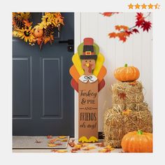 a thanksgiving decoration with hay and pumpkins in front of a door