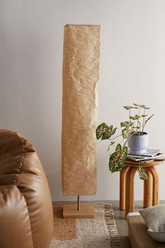 a living room with a brown leather chair and potted plant next to a wooden stand