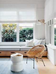 a living room filled with lots of furniture next to a window covered in white curtains