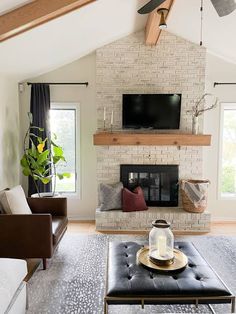 a living room filled with furniture and a flat screen tv mounted on the wall above a fireplace