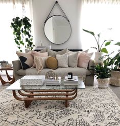 a living room filled with lots of furniture next to a large mirror on the wall