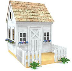 a small white house with flowers in the window boxes and a picket fence around it