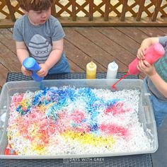 two young boys sitting at a table with a cake