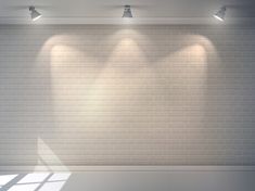 an empty room with three spotlights on the wall