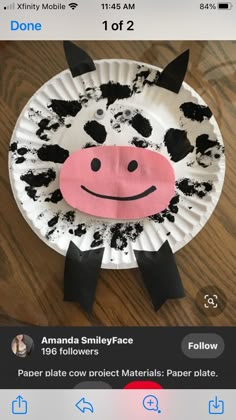 a paper plate that has a cow on it with black spots around the face and nose