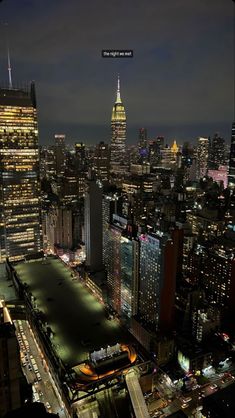 an aerial view of new york city at night with the empire building in the background