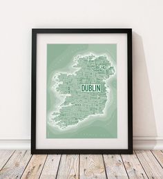 a framed map of dublin in grey and white on a wooden floor with a black frame