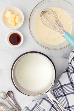 ingredients to make cheesecake in bowls on a white counter top with utensils