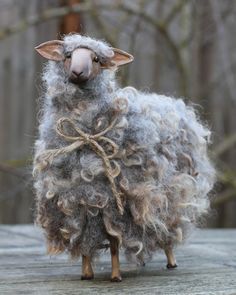 a stuffed sheep is standing on a wooden surface