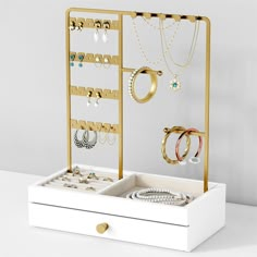 an open jewelry box with rings and bracelets in it on top of a table