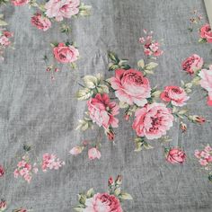 the fabric has pink flowers on it and is very light gray with green leaves,