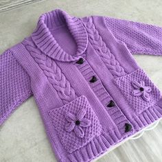 a purple knitted sweater with black buttons