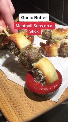 someone is dipping some meatballs on a stick