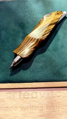 a wooden pen sitting on top of a green cloth