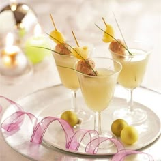 two martinis with olives and garnish on a plate