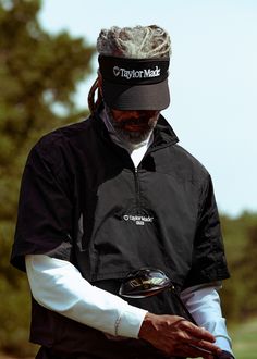 a man wearing a hat and holding a golf club