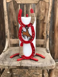 a wooden chair with a red and white horse decoration on it