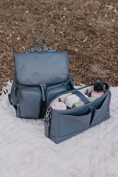 a diaper bag sitting on top of a blanket